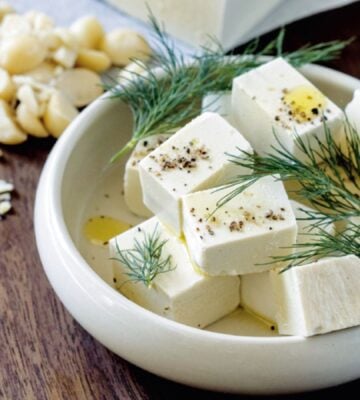 A white bowl filled with homemade macadamia feta, a homemade vegan cheese recipe cooked from scratch