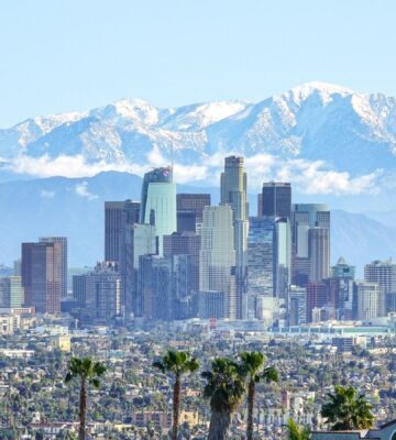 Photo shows the Los Angeles skyline against its backdrop of mountains