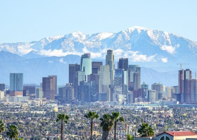 Photo shows the Los Angeles skyline against its backdrop of mountains