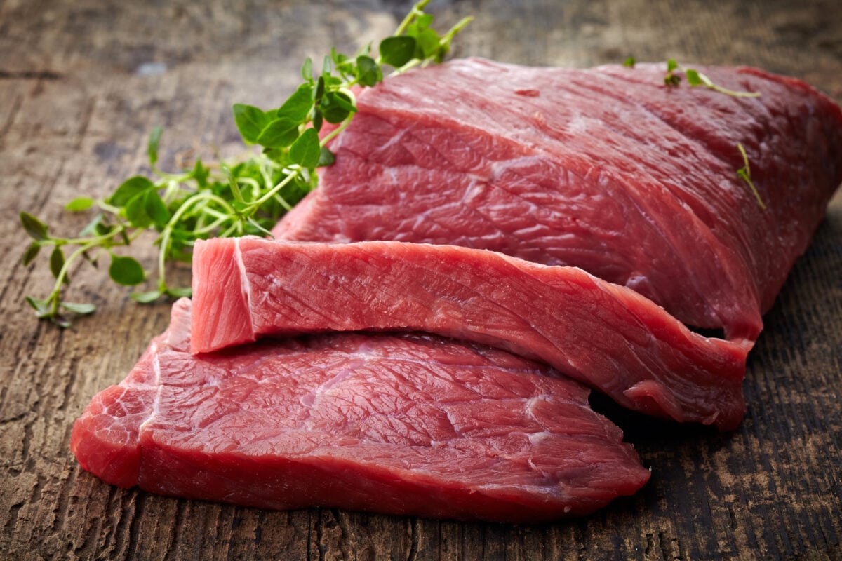 Photo shows a raw, sliced piece of red meat