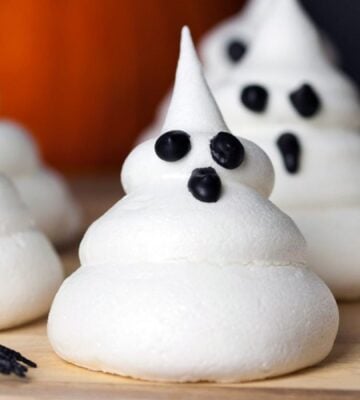 a picture of Halloween ghost meringues with icing faces