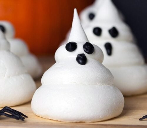 a picture of Halloween ghost meringues with icing faces