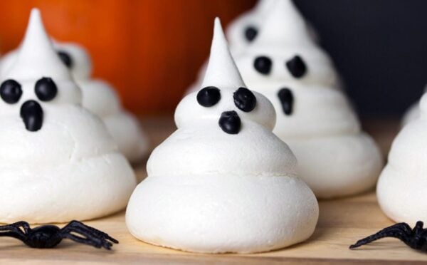 a picture of Halloween ghost meringues with icing faces