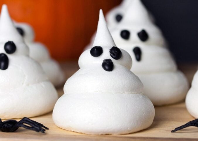 a picture of Halloween ghost meringues with icing faces