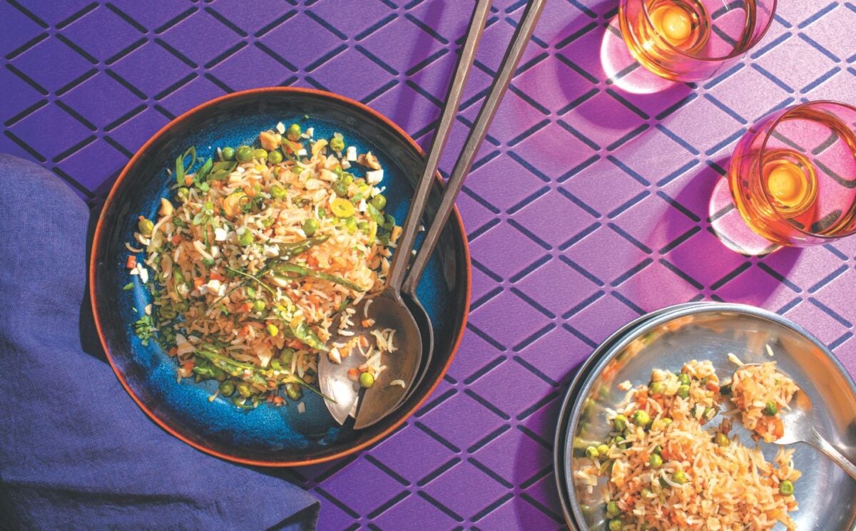 a picture of a plate of Indo-Chinese pulao, a completely vegan fried rice dish with carrots, peas, onion, and cashews