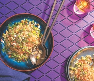 a picture of a plate of Indo-Chinese pulao, a completely vegan fried rice dish with carrots, peas, onion, and cashews