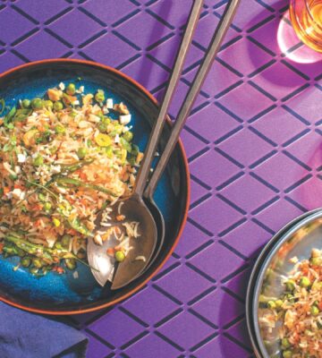 a picture of a plate of Indo-Chinese pulao, a completely vegan fried rice dish with carrots, peas, onion, and cashews
