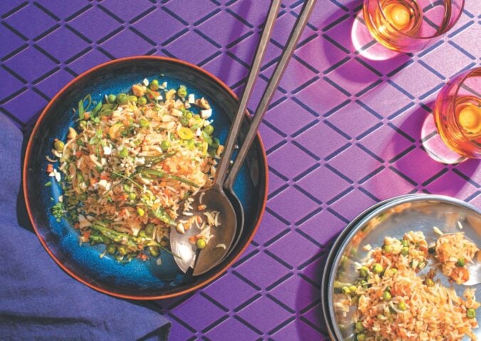 a picture of a plate of Indo-Chinese pulao, a completely vegan fried rice dish with carrots, peas, onion, and cashews