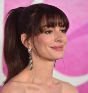 Actor Anne Hathaway on the red carper in front of a pink backdrop