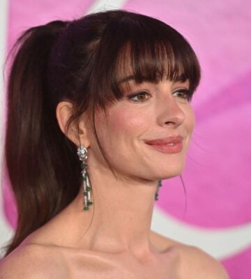 Actor Anne Hathaway on the red carper in front of a pink backdrop