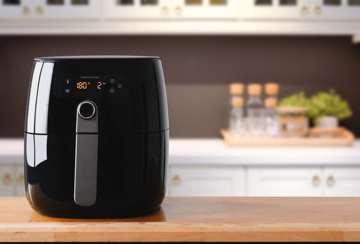 Photo shows a black air fryer on a kitchen worktop