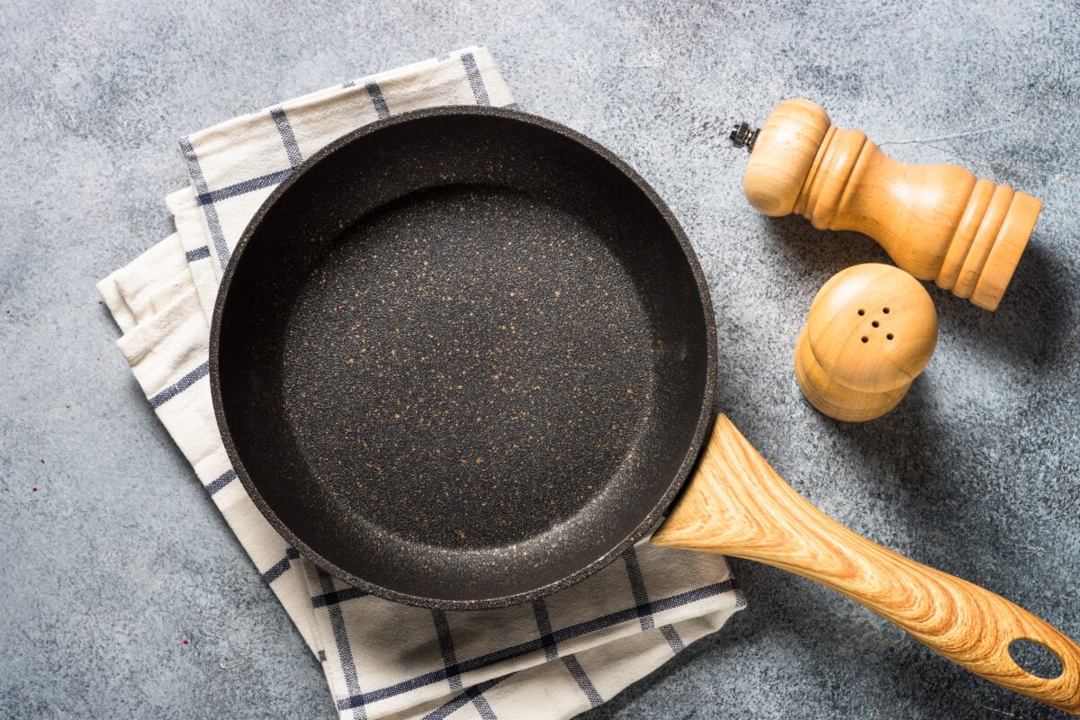 Photo shows a non-stick frying pan on a kitchen towel alongside salt and pepper shakers