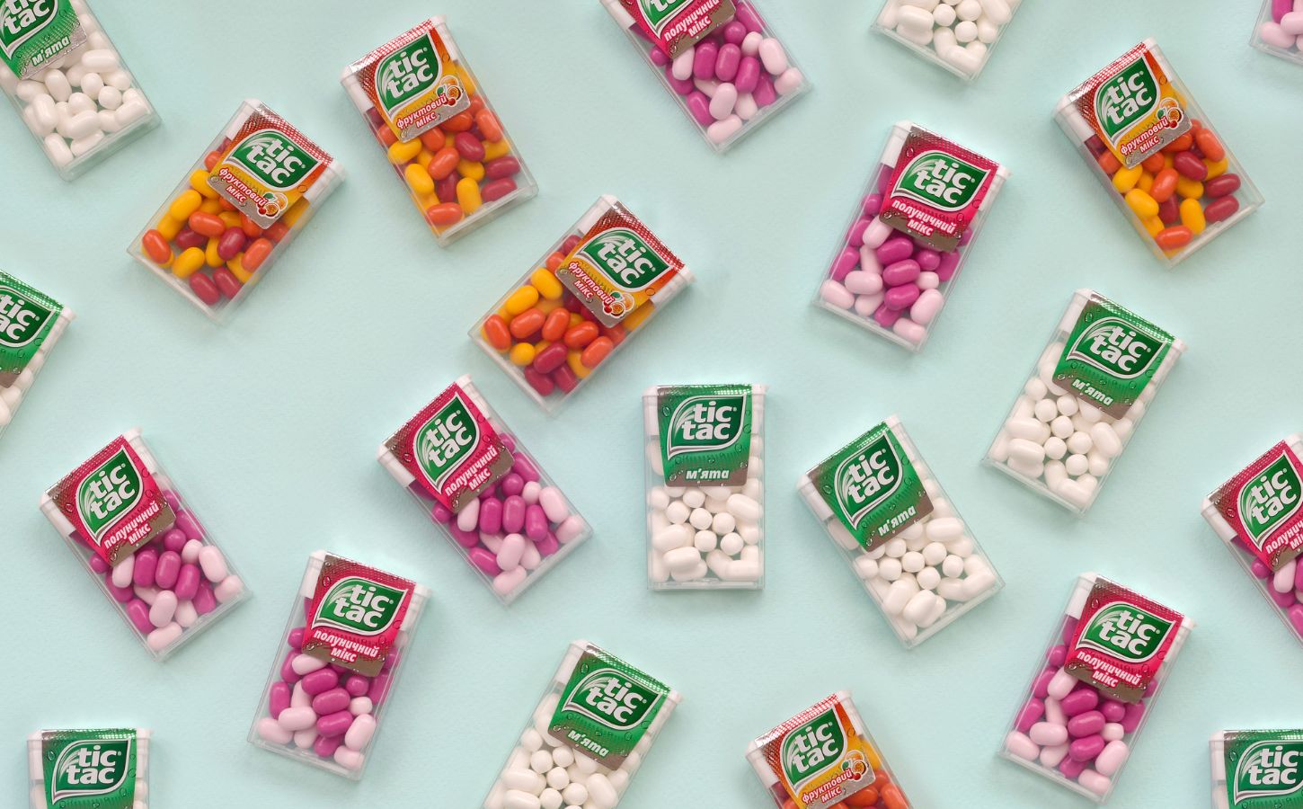 Photo shows a selection of Tic Tac boxes in different flavors and colors on a pale blue background