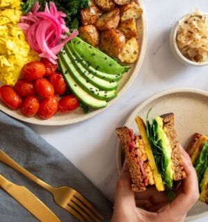 a picture of a vegan big breakfast sandwich made with tempeh, vegan egg, avo, and spinach