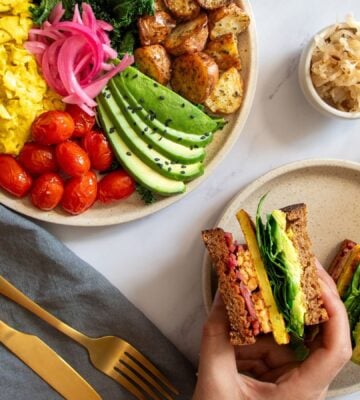 a picture of a vegan big breakfast sandwich made with tempeh, vegan egg, avo, and spinach