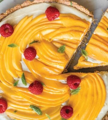 a chai-spiced custard tart with mango with an oat base and raspberry topping