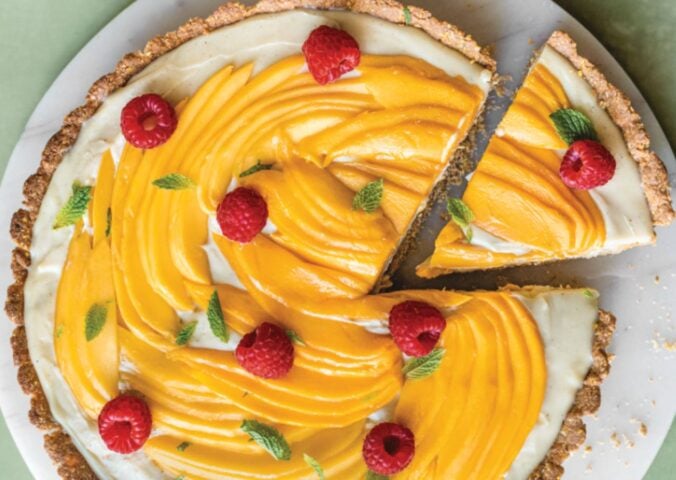 a chai-spiced custard tart with mango with an oat base and raspberry topping