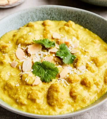 chickpeas and cannellini beans cooked in a coconut milk, carrot, and almond sauce