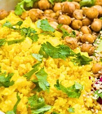 a picture of bright yellow cauliflower rice made with turmeric, lemon, and coriander