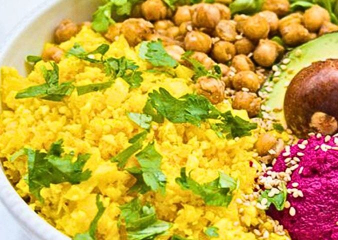 a picture of bright yellow cauliflower rice made with turmeric, lemon, and coriander