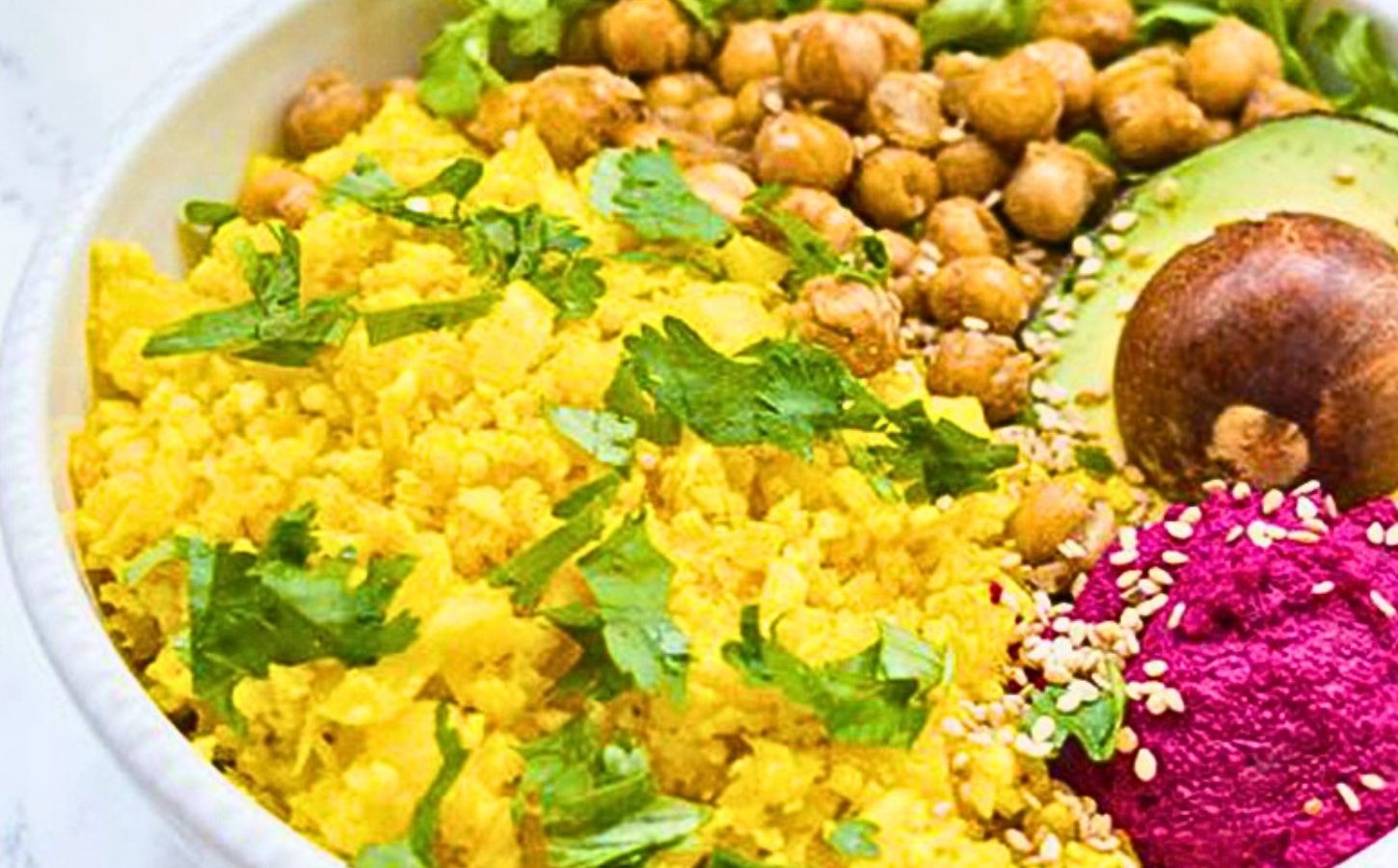 a picture of bright yellow cauliflower rice made with turmeric, lemon, and coriander