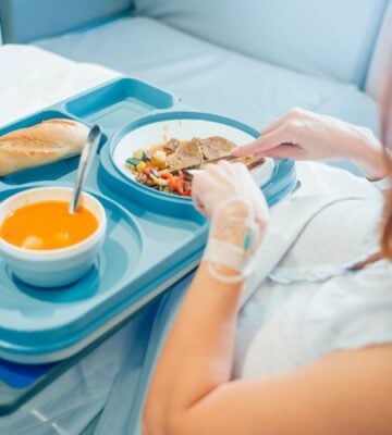 woman eating in hospital bed