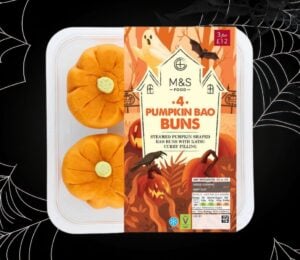 A packet of M&S pumpkin bao buns in front of a black halloween background with cobwebs