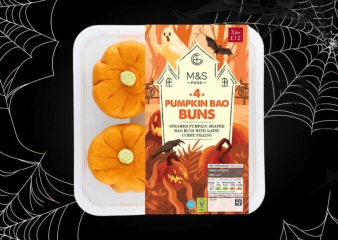 A packet of M&S pumpkin bao buns in front of a black halloween background with cobwebs