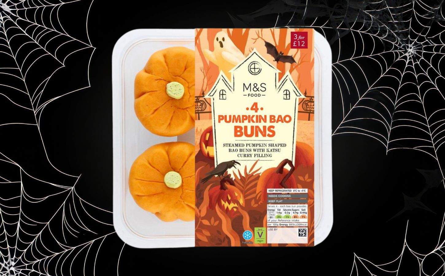 A packet of M&S pumpkin bao buns in front of a black halloween background with cobwebs