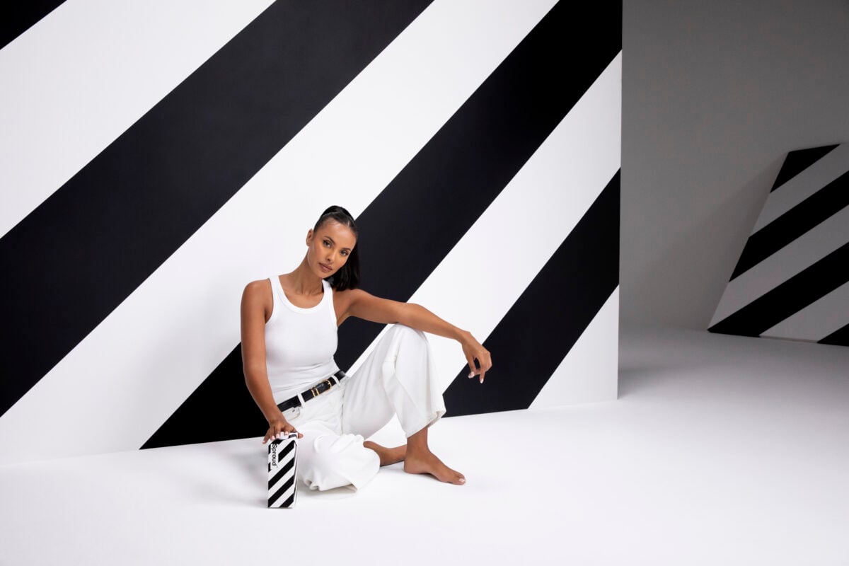 Maya Jama wearing an all white outfit in a black and white room holding a carton on Sproud plant-based milk