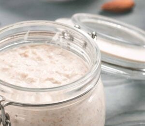 A jar full of vegan overnight oats with chia seeds and maple syrup