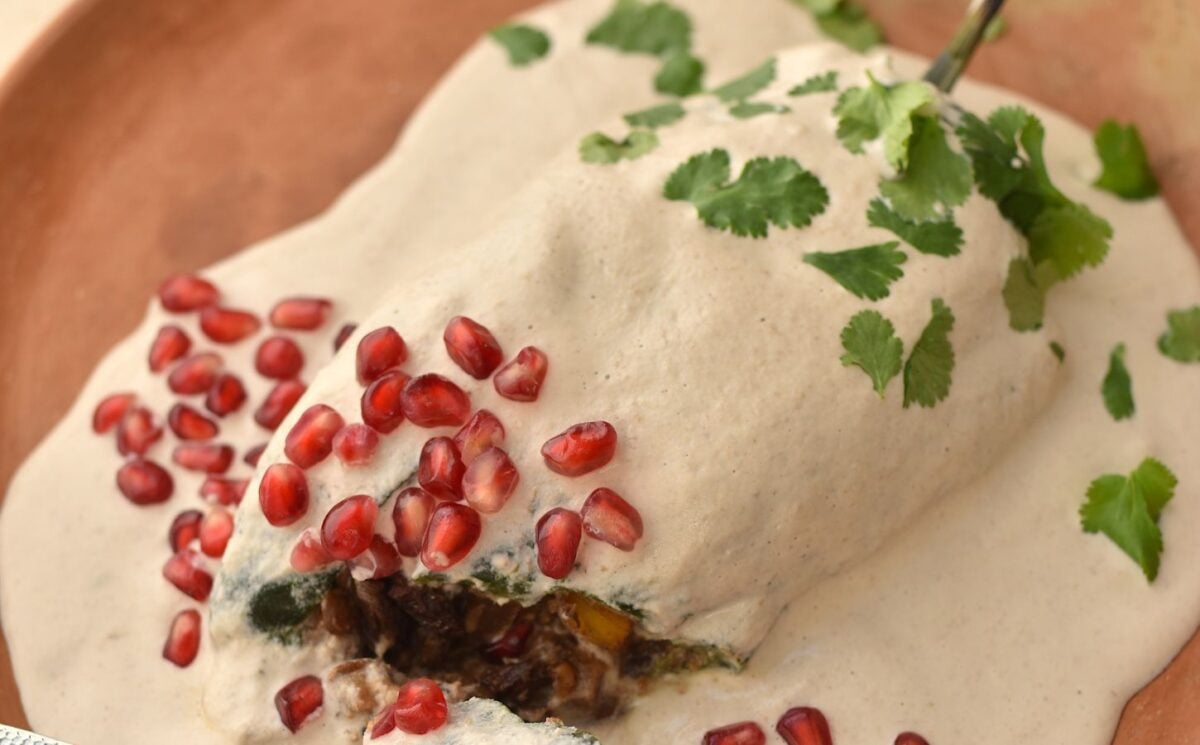 a picture of a stuffed poblano pepper filled with apple, lentils, mushroom, and pear topped with cashew sauce