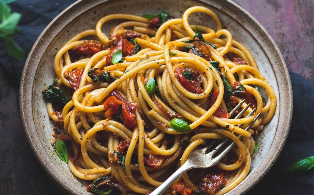 vegan bucatini pasta with sun-dried tomato, tomato, balsamic vinegar, garlic, onion, and baby spinach, vegan Italian recipes