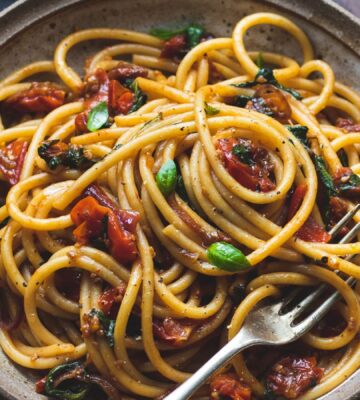 vegan bucatini pasta with sun-dried tomato, tomato, balsamic vinegar, garlic, onion, and baby spinach, vegan Italian recipes