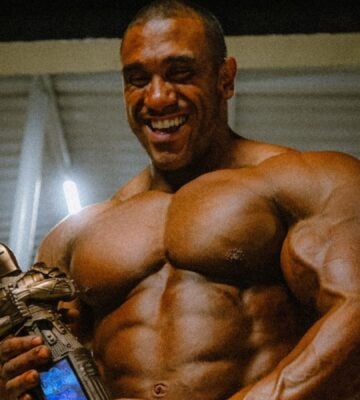 Photo shows Guilherme Oliveira holding his bodybuilding trophy for winning Mr Olympia Brazil