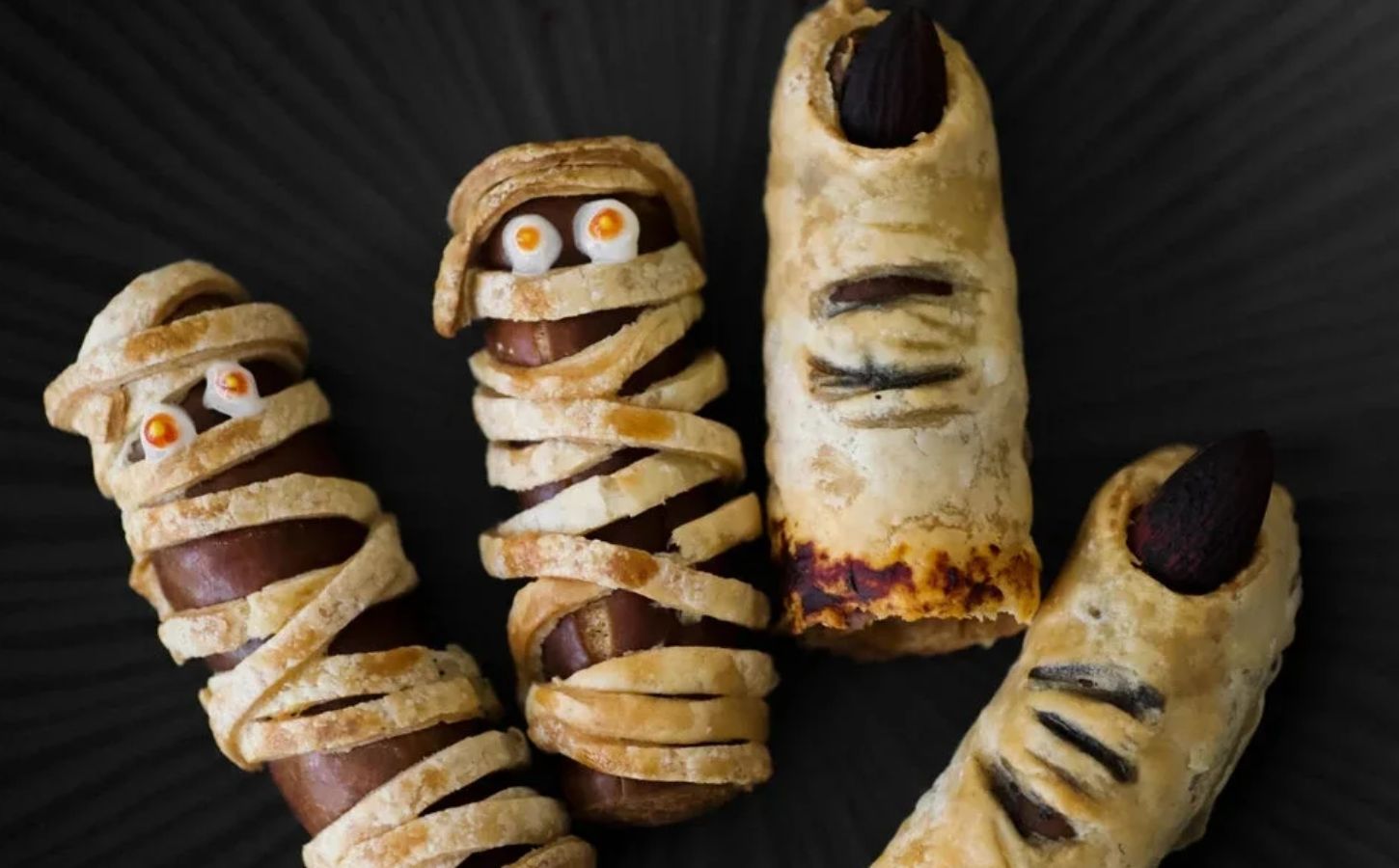 a picture of vegan sausage rolls in the shape of mummies and witch fingers