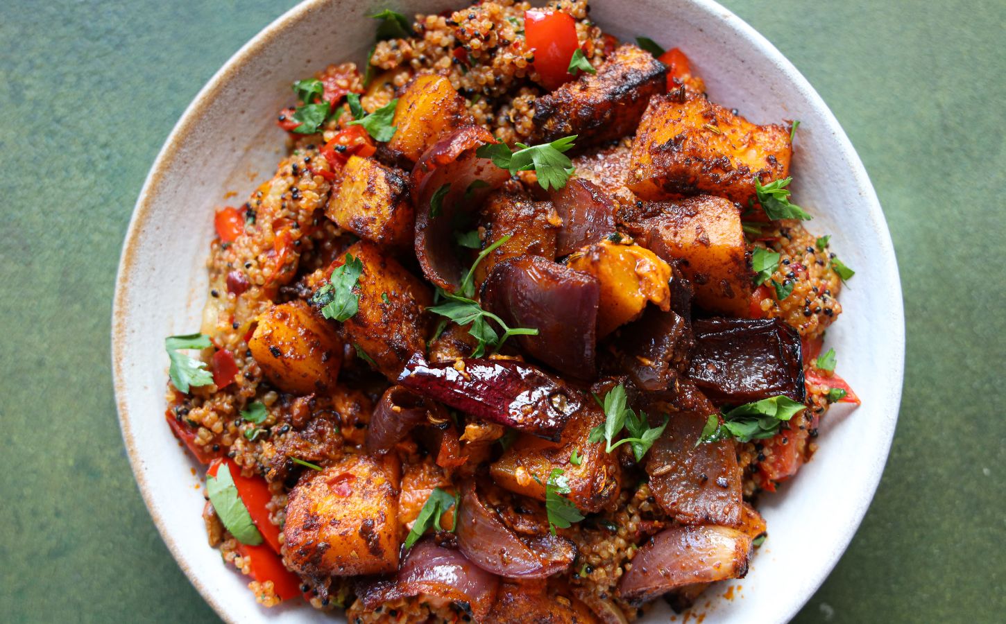 a picture of a speedy squash bowl with butternut, quinoa, tomato, harissa, onion, and red pepper that makes part of the vegan lunches to make in October