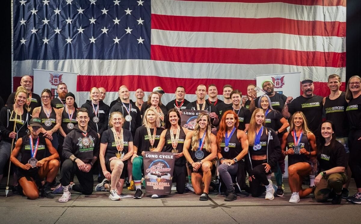 The all-vegan Vegan Strong Plantbuilt team in front of a huge US flat competing at Mr. America