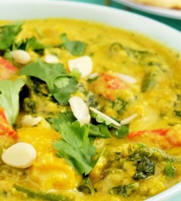 a picture of a vegan vegetable korma made with green beans, spinach, turmeric, and coconut milk