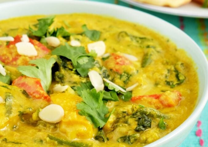 a picture of a vegan vegetable korma made with green beans, spinach, turmeric, and coconut milk