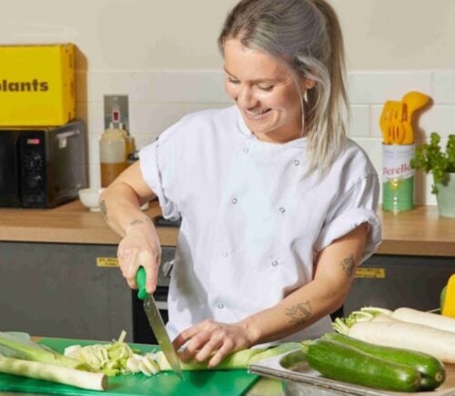 Photo shows Allplants Development Kitchen Assistant Mimi preparing vegetables