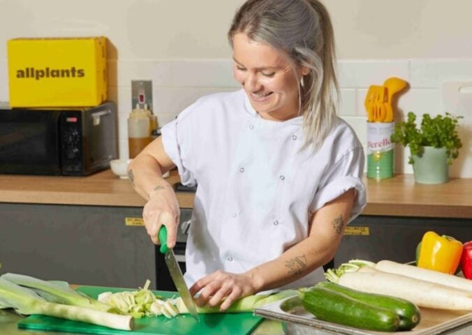 Photo shows Allplants Development Kitchen Assistant Mimi preparing vegetables