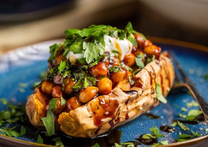 buffalo chickpeas on roasted sweet potato topped with coriander and coconut yogurt