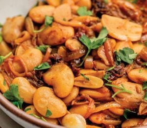 a bowl of caramelized onion butter beans made with sun-dried tomatoes and jammy onions