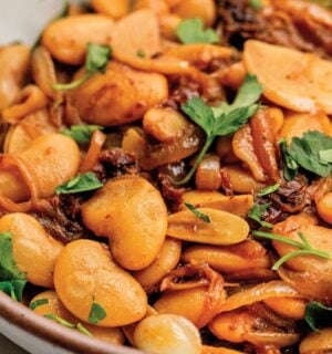 a bowl of caramelized onion butter beans made with sun-dried tomatoes and jammy onions