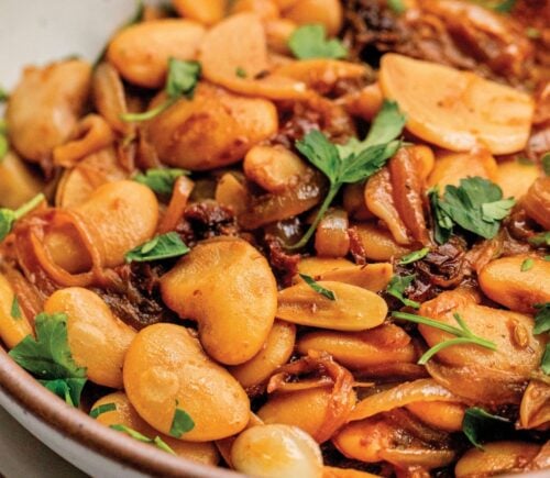 a bowl of caramelized onion butter beans made with sun-dried tomatoes and jammy onions