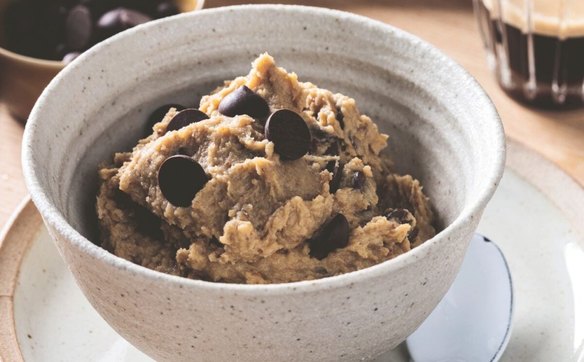 a bowl of chickpea cookie dough with dark chocolate chips, protein powder, and peanut butter