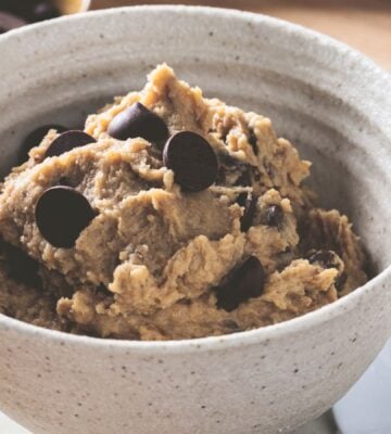 a bowl of chickpea cookie dough with dark chocolate chips, protein powder, and peanut butter