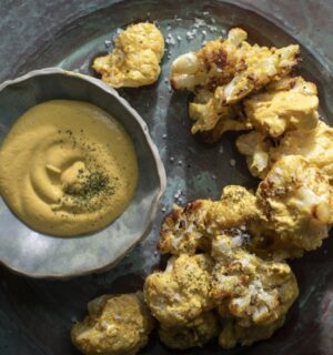 a picture of coliflor frito or crispy cauliflower served with cashew nacho cheese