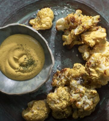 a picture of coliflor frito or crispy cauliflower served with cashew nacho cheese